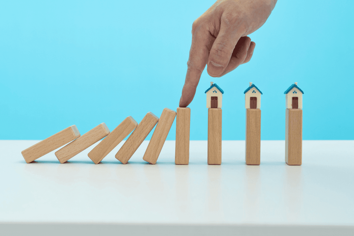 property chain - Man hand stop dominoes from falling on the house