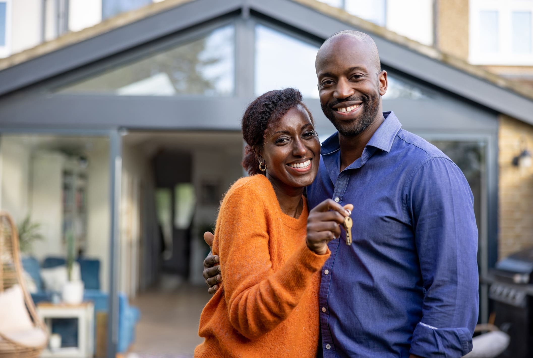 Couple holding a key to their house - The Process of Buying a House UK||||The Process of Buying a House in the UK
